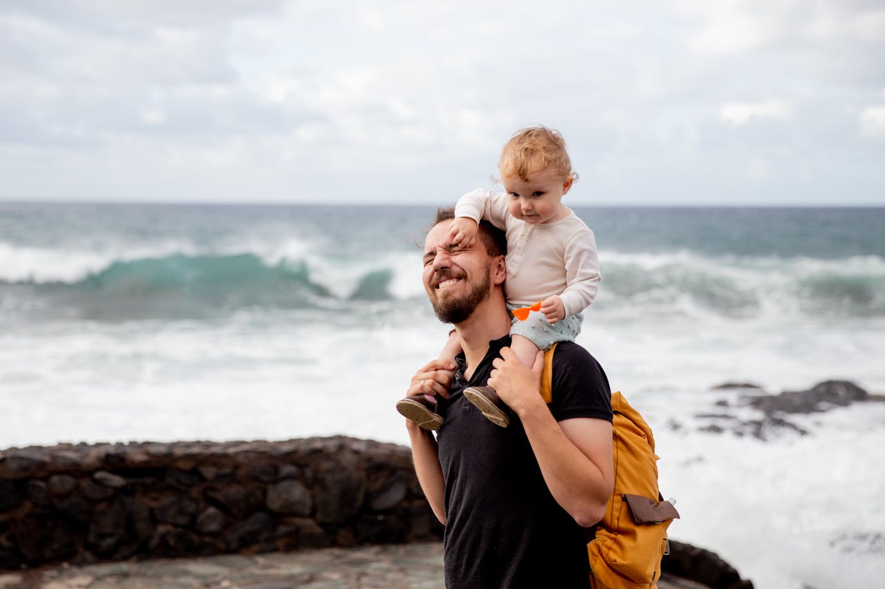A joyful father and child enjoying time together by the ocean, capturing precious bonding moments.
